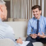 A smiling businessman in a blue suit and shirt receives advice from an ethical debt collector